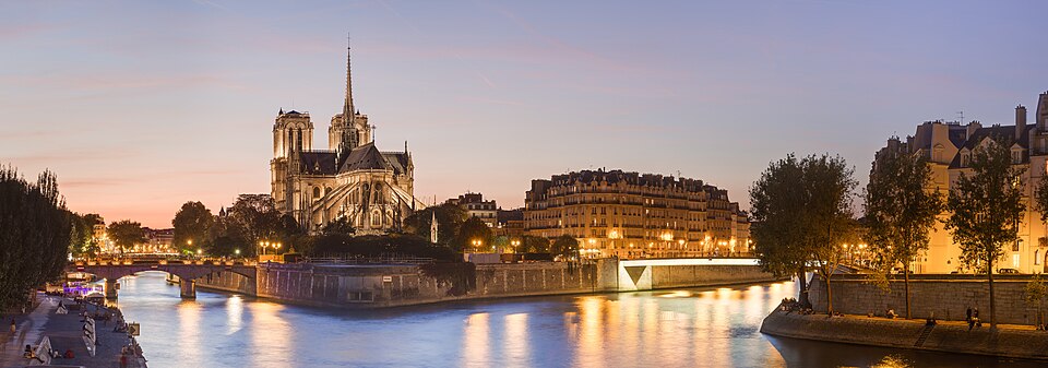 Notre-Dame cathedral and the Île de la Cité glowing at dusk above the Seine
